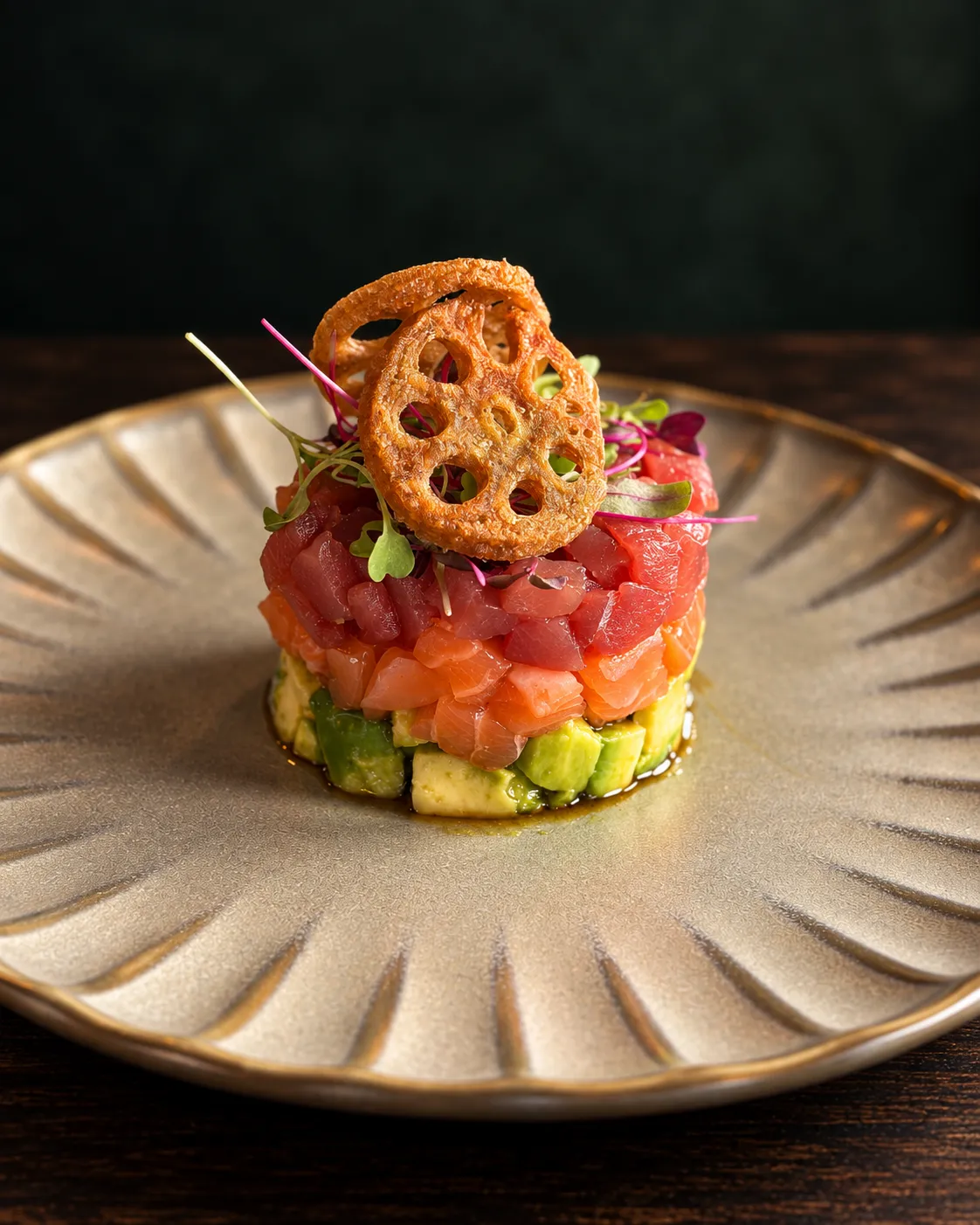 Layered tuna, salmon and avocado tartare topped with lotus-root crisps